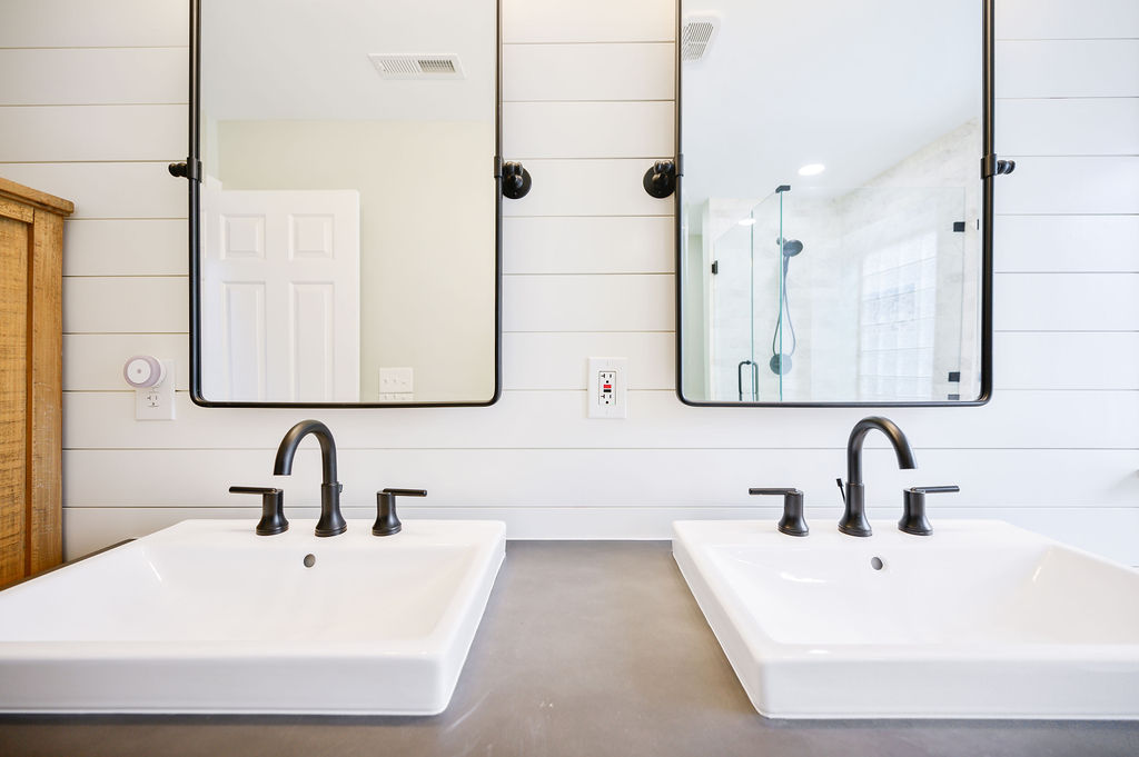 “Concrete” countertops and matte black pivot mirrors